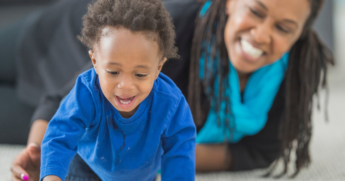 cdc developmental milestones a young black toddler learning to crawl with his mother 