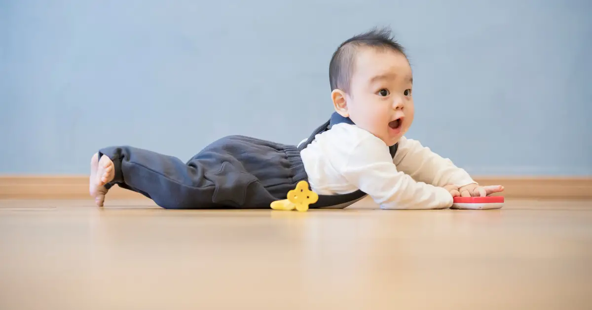 cdc developmental milestones - crawling - asian baby boy on tummy