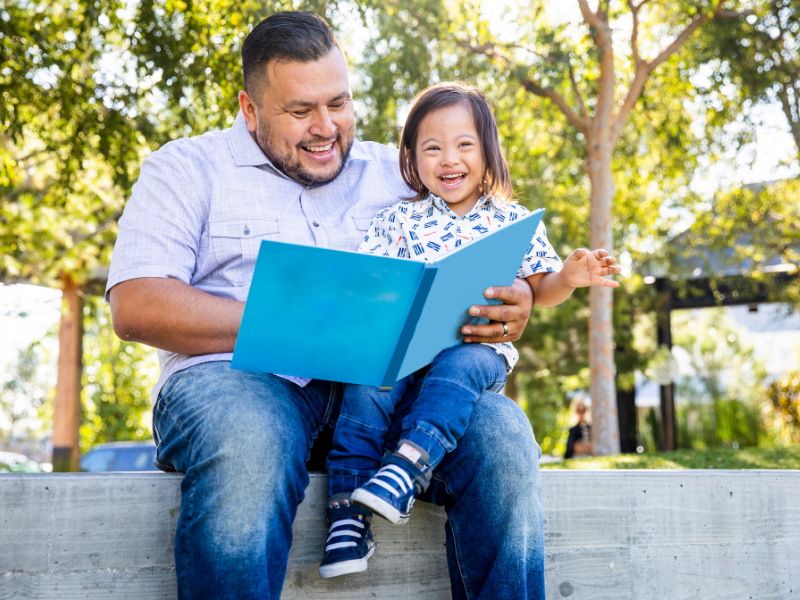 dad reading to child in the park