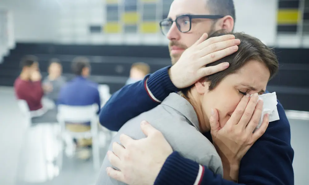grieving parents hug each other