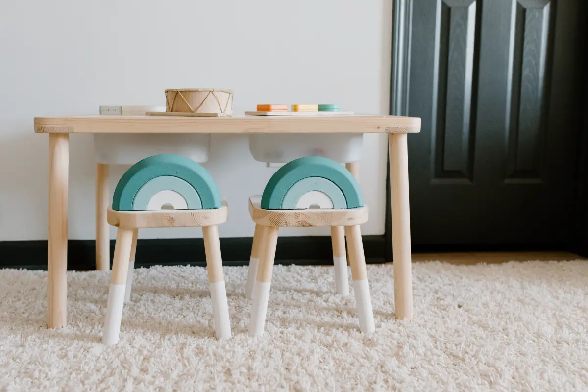Wooden toddler table with two rainbow backed wooden stools. 