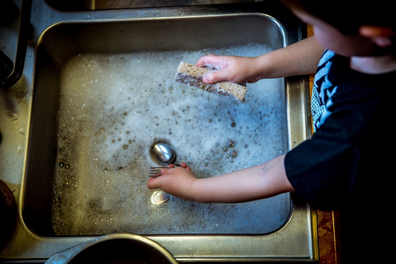 child washing dishes